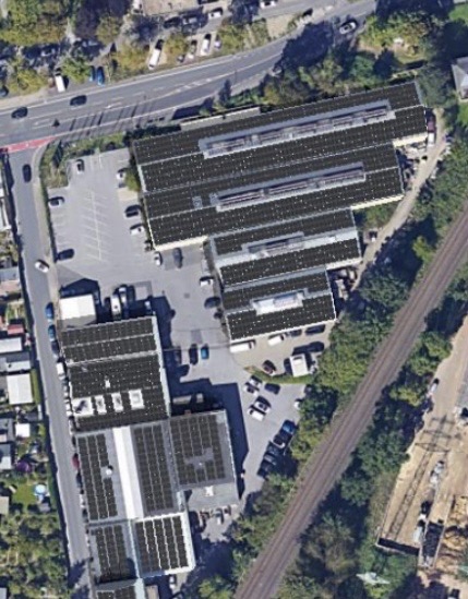 Luftbild der Gewerbeanlage in Düsseldorf mit 878 kWp Photovoltaik auf mehreren Hallendächern